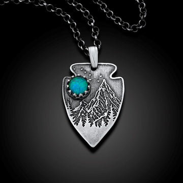Silver pendant with mountain design and turquoise stone